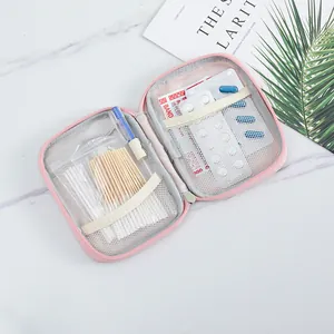 Close-up of open pink portable medicine bag with internal mesh pockets and medical supplies