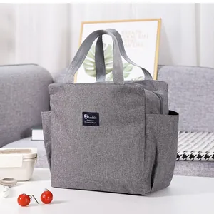 Bolsa de almuerzo aislada de tela Oxford gris con asas y bolsillos para el picnic