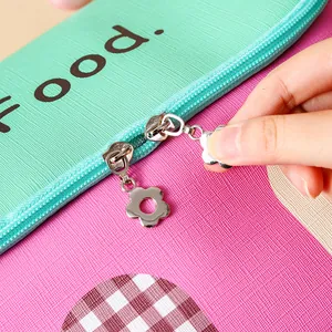 Cute insulated lunch bag featuring floral metal zippers and mint pink textured surface