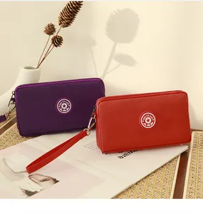 Portefeuilles longs en nylon rouge et violet avec dragonnes dans un décor chaleureux