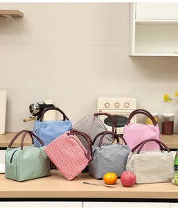 Collezione di sette borse termiche a righe colorate esposte in un ambiente cucina.
