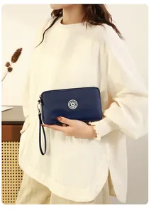Vue détaillée de l'élégante pochette bleue à grande capacité avec une dragonne pratique.