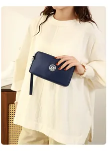 Mannequin tenant une pochette rectangulaire en nylon bleu marine avec dragonne pratique