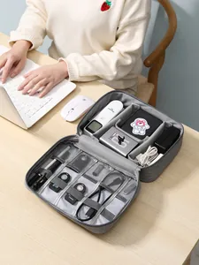 Vista detallada de una bolsa organizadora gris para cables y electrónica de viaje