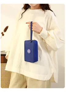Pochette de téléphone en tissu bleu à trois couches avec dragonne tenue par un mannequin