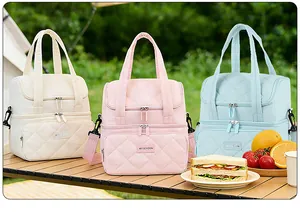 Drei bunte doppelschichtige isolierte Kühltaschen in einer sonnigen Picknick-Szene