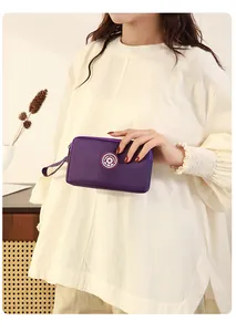 Vue détaillée d'une pochette en tissu violette à trois couches tenue par un mannequin