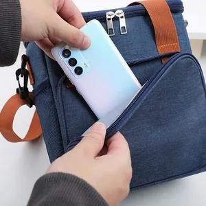 Durable blue insulated picnic lunch bag with front zipper pocket for phone storage.