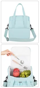 Detaillierte Innenansicht einer hellblauen Isoliertasche mit Obst und einer Netztasche für Besteck