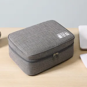 Organizador de viaje de tela gris para cables, cargadores y baterías externas portátiles.