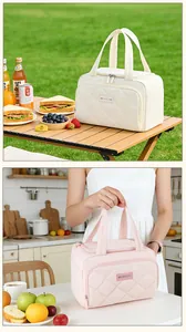 Detail van gewatteerde geïsoleerde lunchtas in wit en roze voor dagelijks woon-werkverkeer.