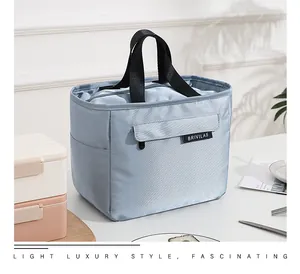 Close-up of light blue insulated lunch bag highlighting the front logo and fabric texture