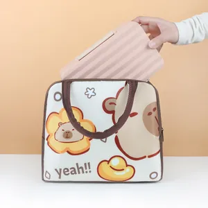 A person placing a pink striped lunch box into a cute cartoon patterned insulated lunch bag