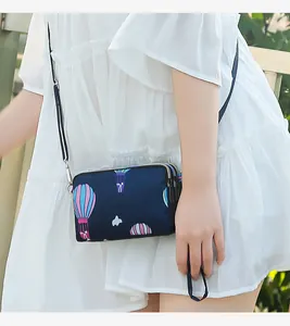 Close-up of navy blue crossbody phone bag with hot air balloon print and three layers.