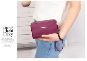 Primer plano de un bolso de mano de nailon morado con varias cremalleras