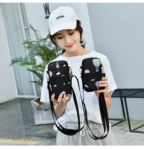 Asian model holding two black printed crossbody phone bags with hot air balloon patterns