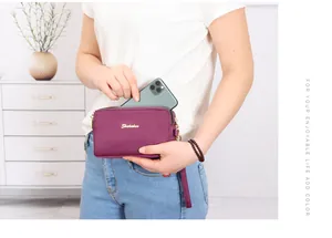 Bolso de mano de nailon morado que muestra un smartphone entrando en el bolsillo.
