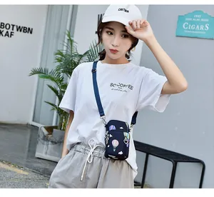 Asian model wearing a blue printed crossbody phone bag in a casual urban setting