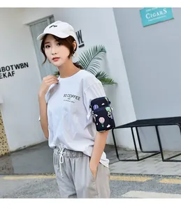 Close-up of a stylish printed smartphone arm bag worn by a model in an outdoor setting