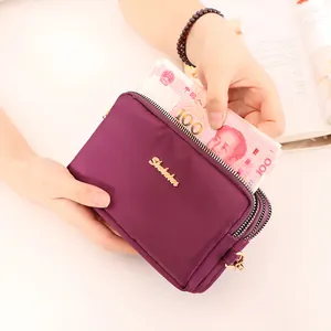 Cartera monedero de nailon morado para móvil con múltiples cremalleras y billetes.