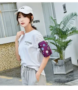 Outdoor lifestyle detail of a purple printed arm bag worn on a woman's arm