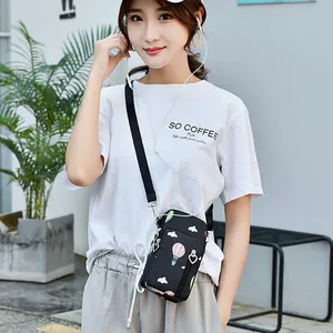 Small black crossbody phone bag for women with balloon print worn by Asian model