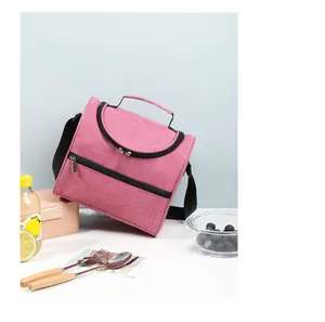 Portable pink insulated lunch bag in a lifestyle setting with picnic props