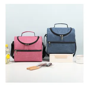 Detail view of pink and blue insulated lunch bags with handheld and crossbody straps.