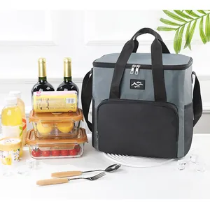 Borsa termica per picnic grigia e nera mostrata in una scena di pranzo all'aperto