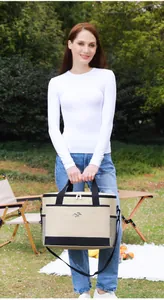 Große beige und schwarze isolierte Picknick-Kühltasche in einer Gartenumgebung