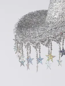 Macro detail of a silver glitter cowboy hat featuring sparkling sequin star tassels.