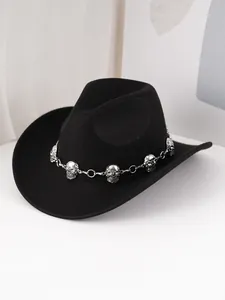 Gros plan d'un chapeau de cowboy en feutre noir avec chaîne tête de mort gothique.