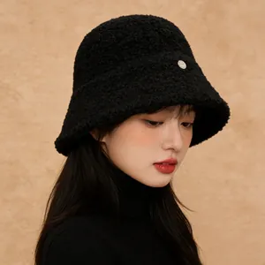 Detail of a black granular wool bucket hat with silver metallic badge for winter.