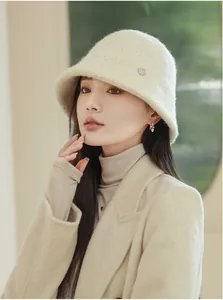 Detailed shot of a stylish cream fuzzy wool bucket hat worn by a model in winter.
