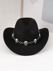 Gros plan d'un chapeau de cowboy noir avec une chaîne à têtes de mort en argent, style punk.