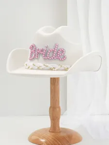 Detailansicht eines weißen Braut-Cowboyhutes mit rosa Perlen-Schriftzug und Schleier.