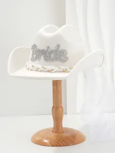 Nahaufnahme eines weißen Braut-Cowboyhuts mit Bride-Schriftzug aus Strass und Perlen
