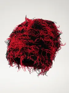 Detailansicht einer roten und schwarzen, zotteligen Strickmütze im Punk-Stil für Hip-Hop