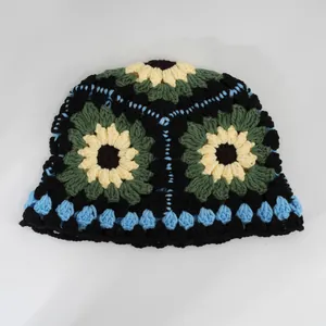 Dettaglio ravvicinato di un vivace cappello pescatore a uncinetto con girasoli fatti a mano.
