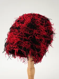 Detail einer zotteligen rot-schwarzen Strickmütze mit einzigartiger flauschiger Textur für Punk