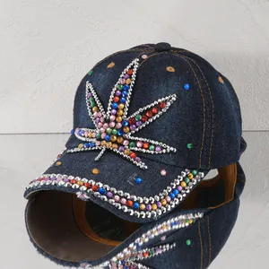 Nahaufnahme eines farbigen Strass-Hanfblatts auf einer dunkelblauen Denim-Kappe
