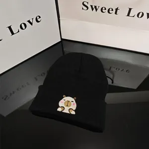 Close-up of a black knit beanie featuring a cute embroidered capybara cartoon character