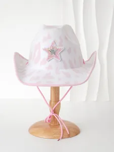 Detailansicht eines rosa-weißen Cowboyhuts mit Kuhmuster und Paillettenstern für Partys