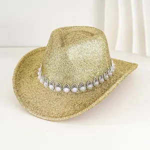 Detalle de sombrero vaquero dorado con purpurina y banda decorativa de perlas y strass