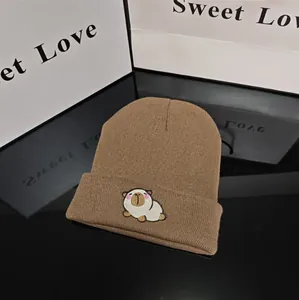 Close-up of a brown knitted winter beanie hat featuring a cute Capybara embroidery detail