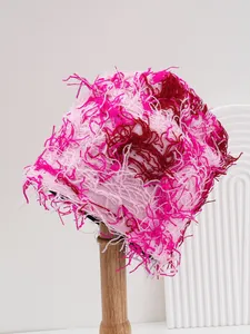 Detailed view of a pink fuzzy knit hat featuring a distressed camouflage pattern and shaggy texture