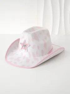 Detail eines pinkfarbenen Cowboyhuts mit Kuhmuster und funkelndem Sternenaufnäher