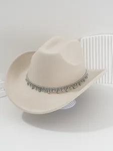 Dettaglio di un cappello da cowboy beige con un bordo scintillante di frange in strass