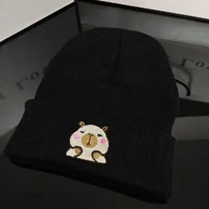 Cozy black winter knit beanie hat featuring a cute embroidered Capybara cartoon character