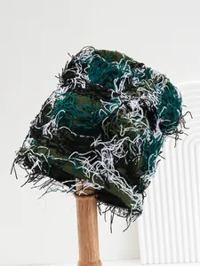 Close-up detail of distressed camouflage knitted beanie featuring frayed fringe texture